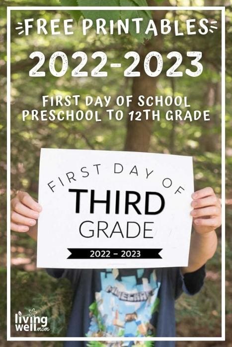 boy holding up paper that says first day of third grade 2022-2023 in green wooded background