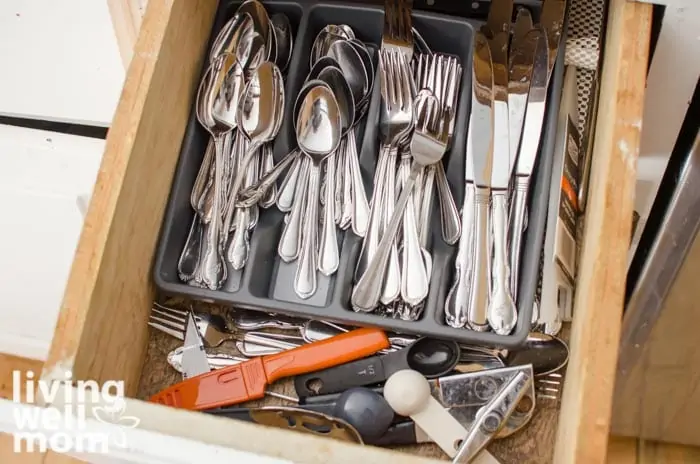 a disorganized drawer in a small kitchen