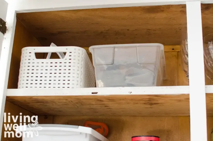 organized bins on a shelf of a kitchen cabinet