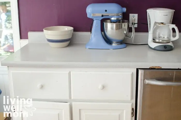 a kitchen countertop with a mixer, bowl and coffee maker on top. 