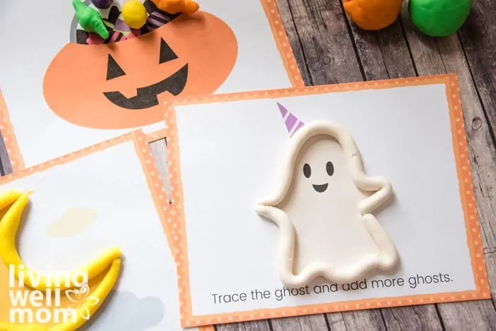 white playdough used to trace the image of a ghost for a Halloween kids activity 