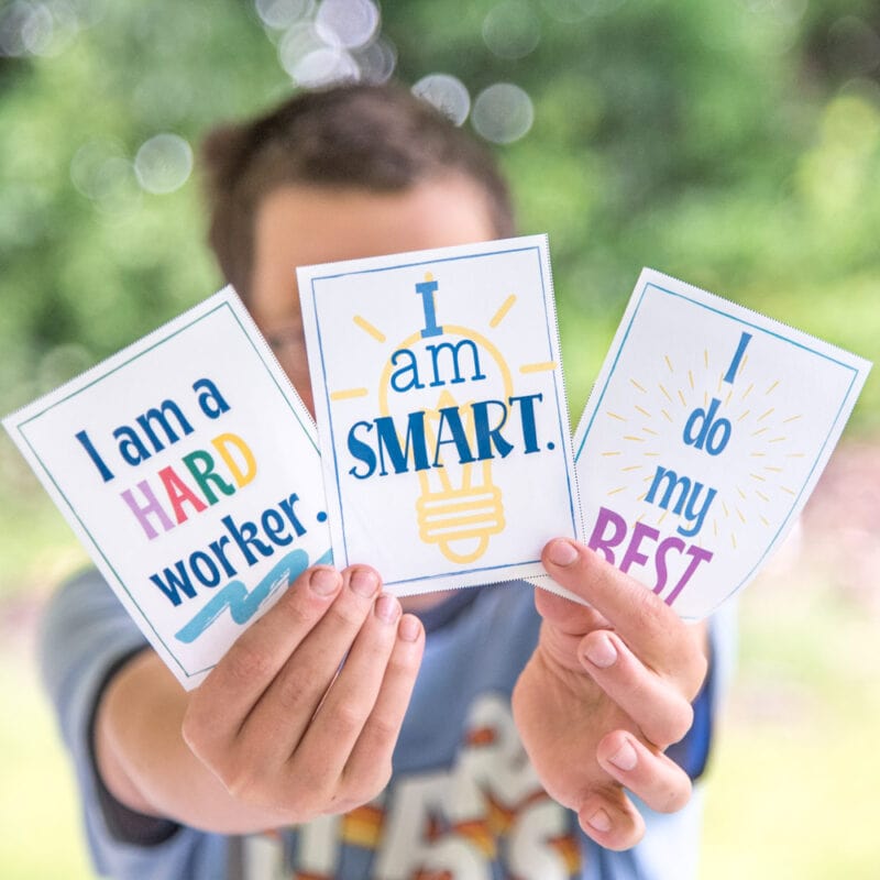 boy holding positive affirmation cards