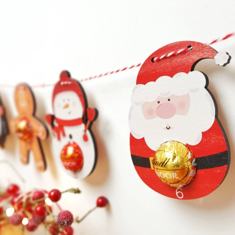 wooden hanging advent characters with candy on each