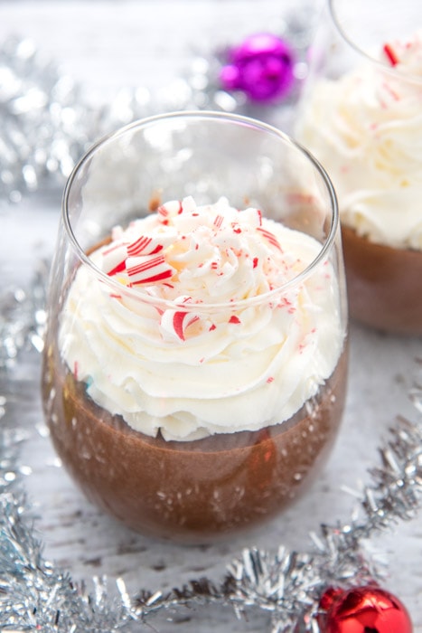 chocolate peppermint cream pudding with whipped cream and tinsel in background