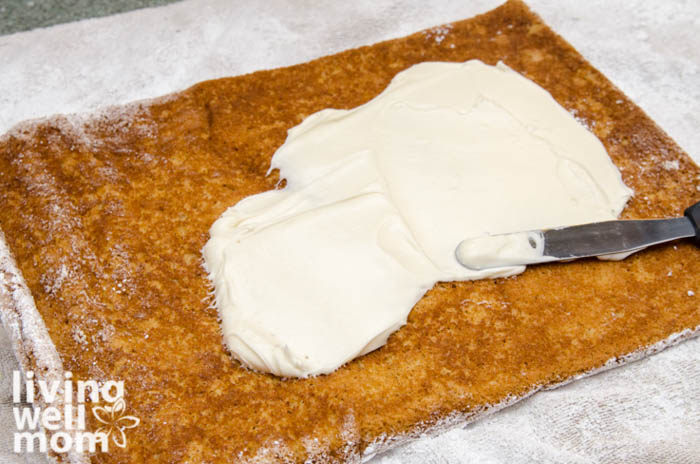 evenly spread cream cheese filling over sponge cake