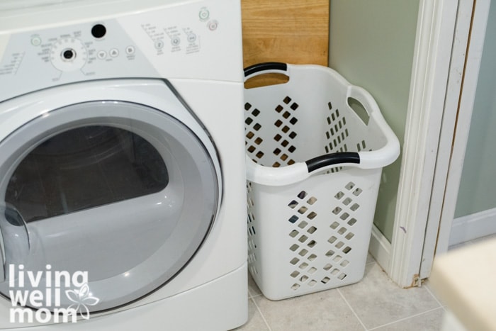laundry basket next to washer in clean laundry room