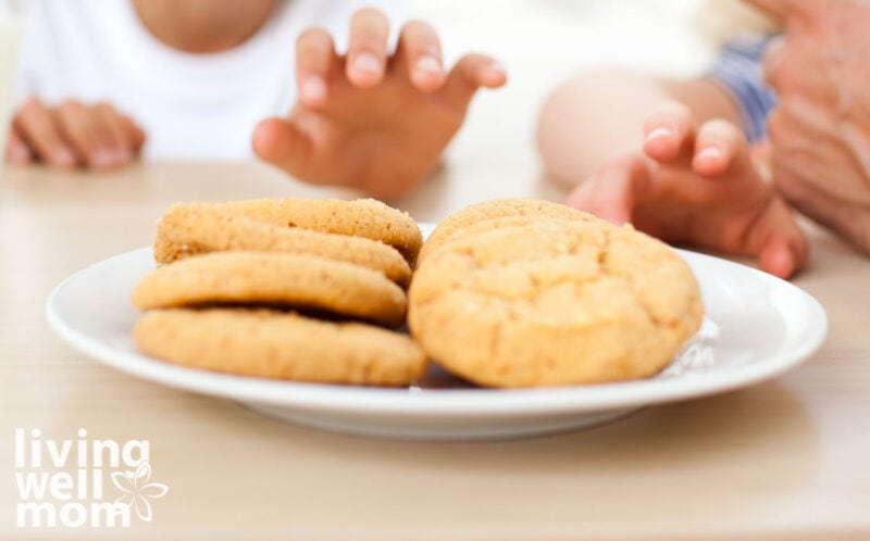 hands reaching for peanut butter cookies on a plate