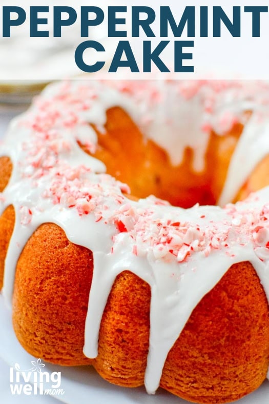 Close up of a Christmas bundt cake with white icing and crushed candy cake topping.