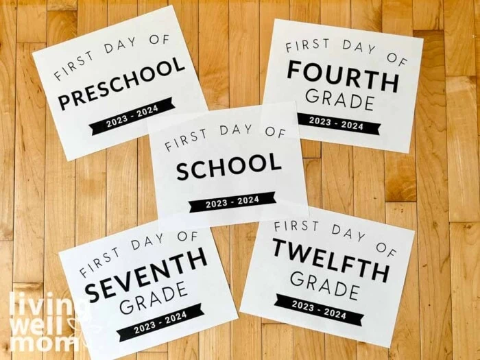 first day of school printed signs for preschool through twelfth grade 2023 on light wood background