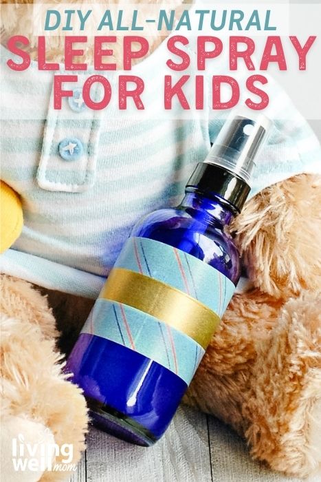 Stuffed teddy bear holding a glass spray bottle of diy sleep spray for kids
