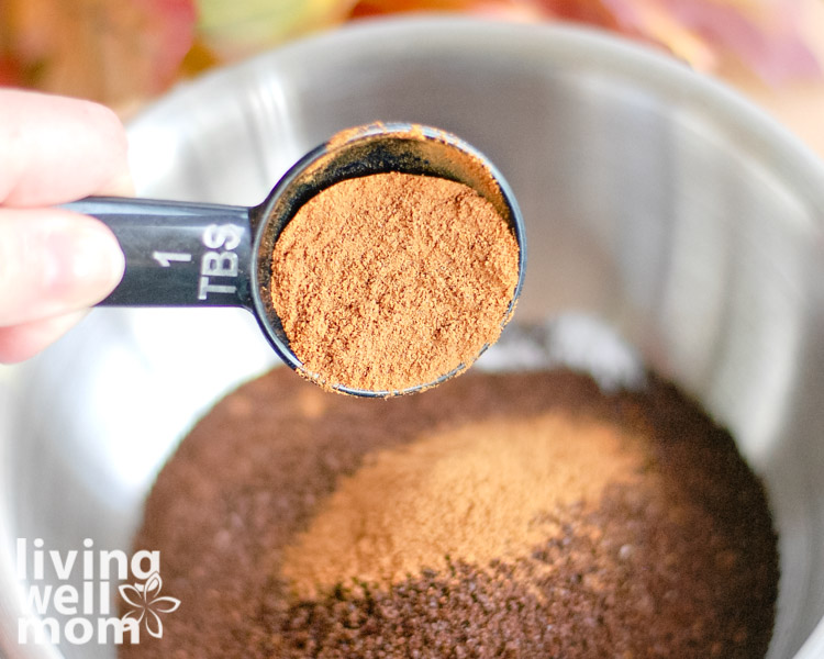 cinnamon being poured on top of coffee grounds