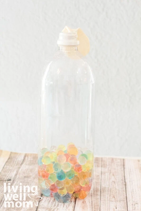 plastic bottle filled with orbeez with deflated balloon attached to top