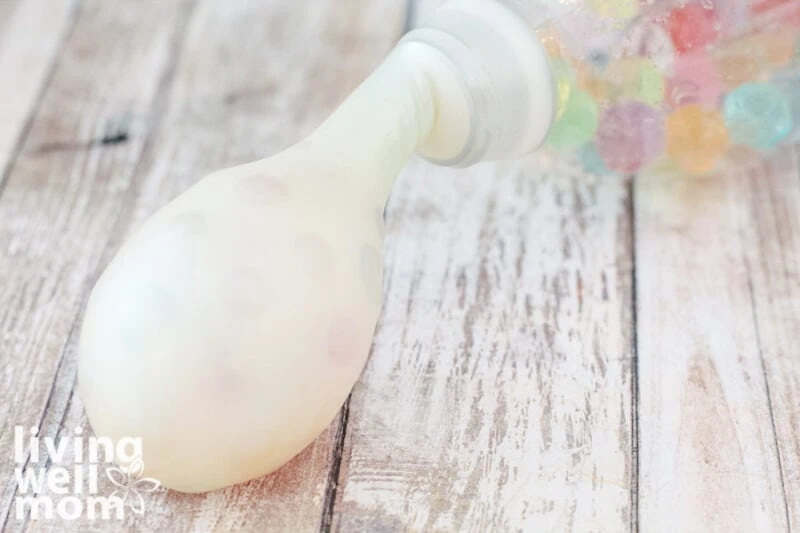 white balloon being filled with water beads