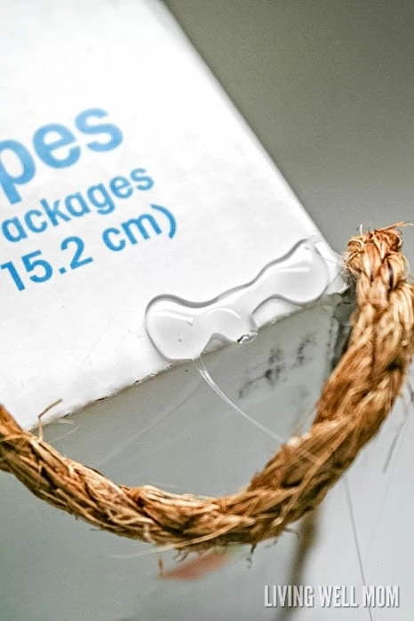 closeup view of gluing rope to a cardboard box