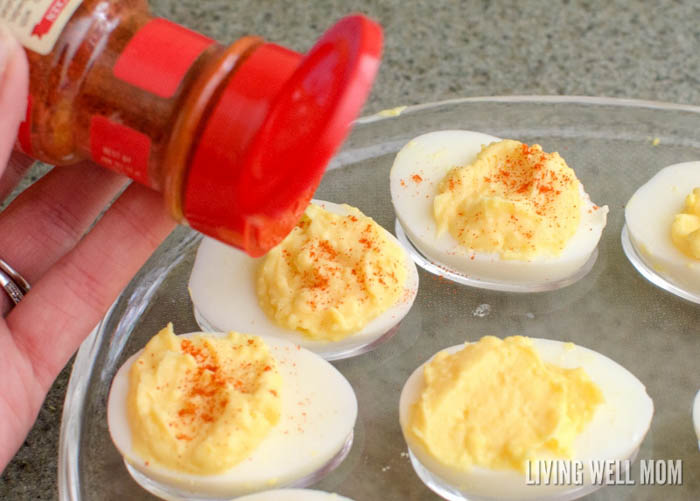 sprinkling paprika on deviled eggs