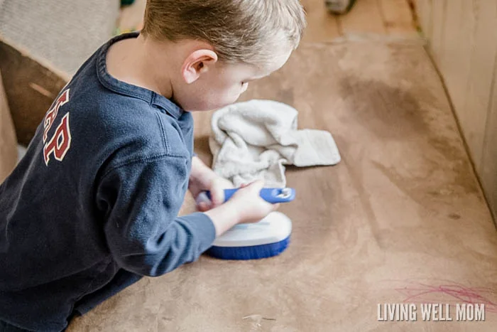 boy cleaning couch with scrub brush
