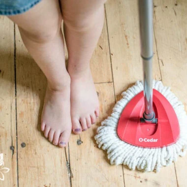 close up of child's feet with a mop