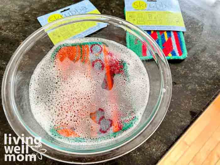 soaking sponge in bowl of water, vinegar and lemon juice