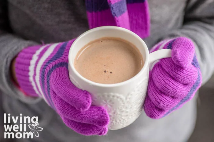 gloved hands holding warm drink