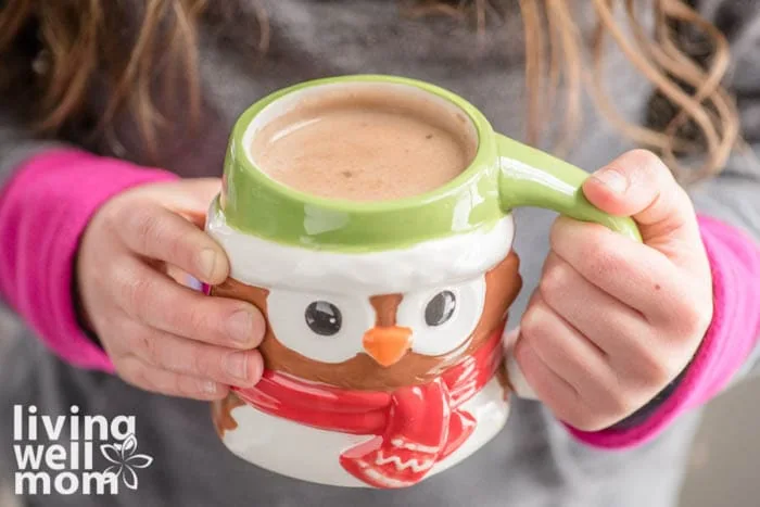 kid holding a mug of hot cocoa