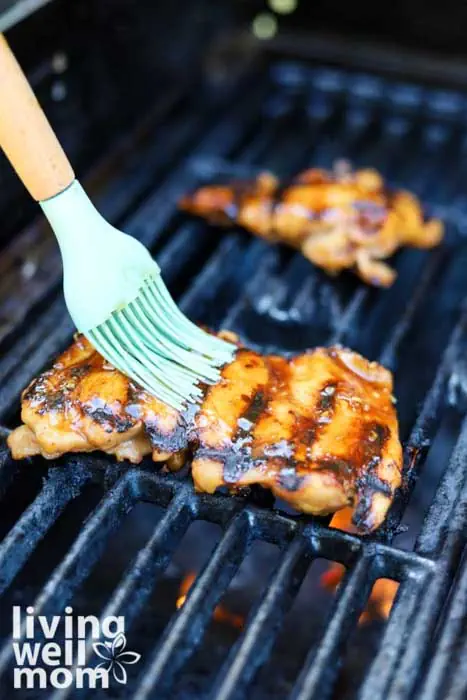 brushing more marinade onto meat on grill