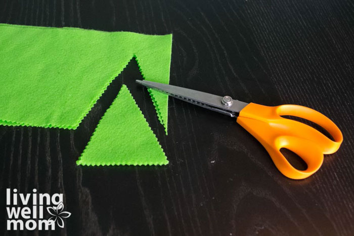 scissors cutting green felt triangles