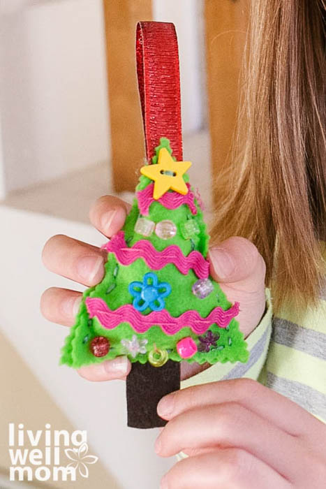 girl holding a decorated tree ornament