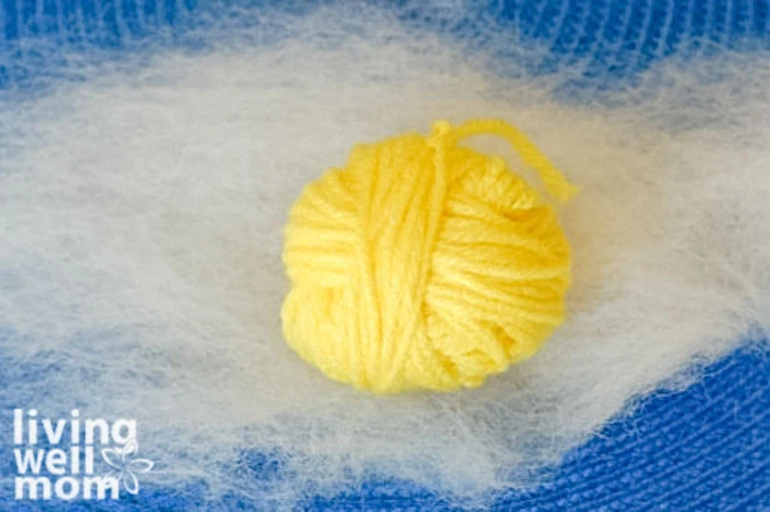 yellow yarn ball ready to be wrapped in wool fibers