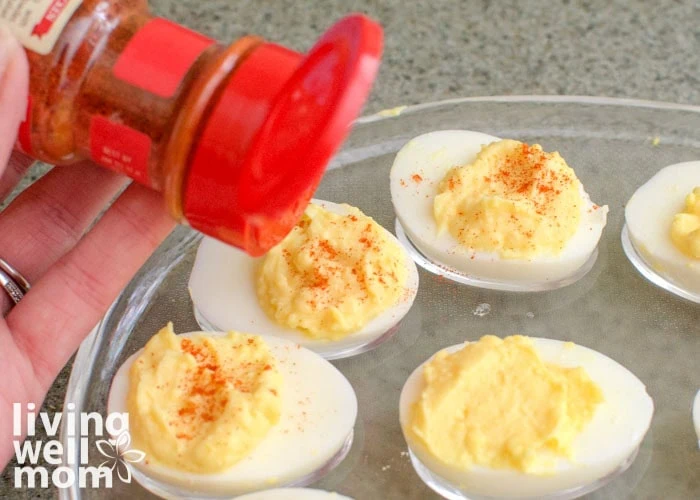 sprinkling paprika on deviled eggs