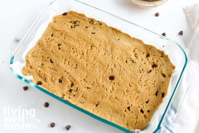 cookie bar dough spread evenly in brownie pan