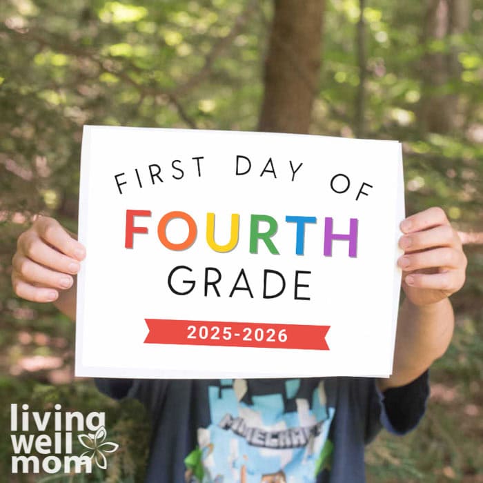child holding up a first day of school printable sign for photos