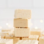 Squares of creamy eggnog fudge arranged on a plate.