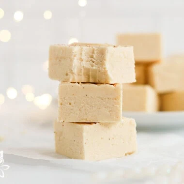 Stack of eggnog fudge pieces showing the soft, creamy interior.