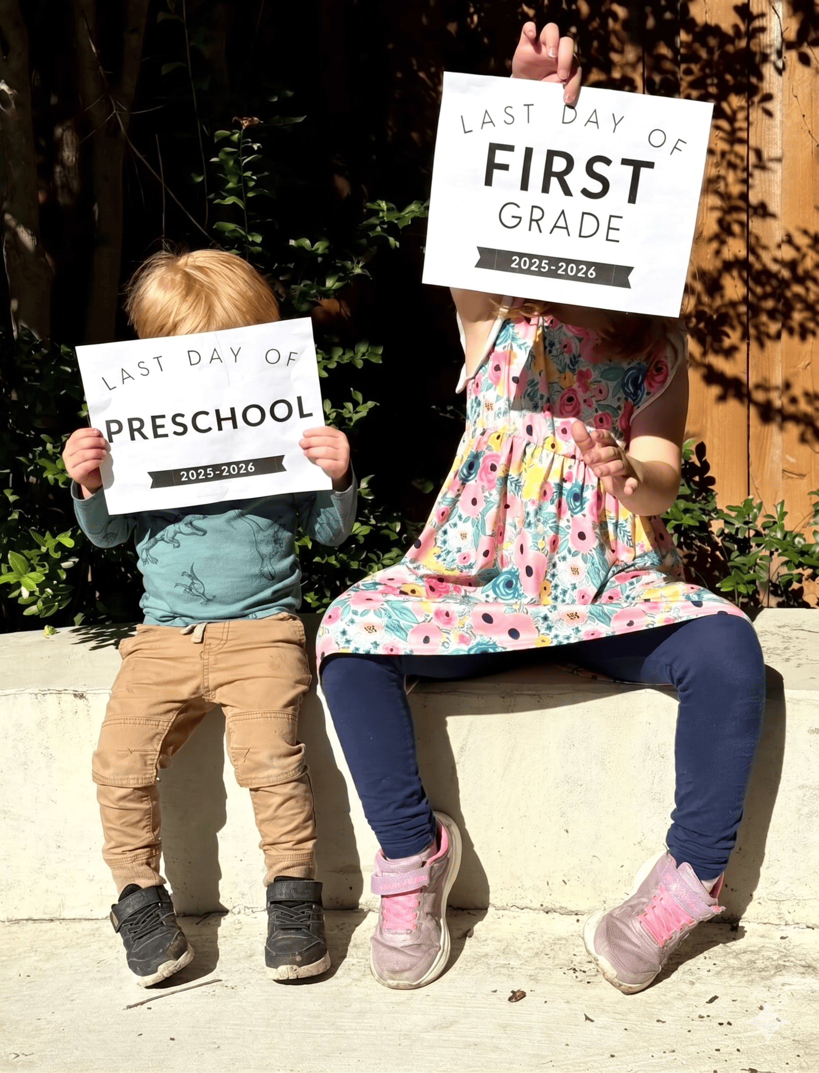 2 children holding last day of school signs for 2026