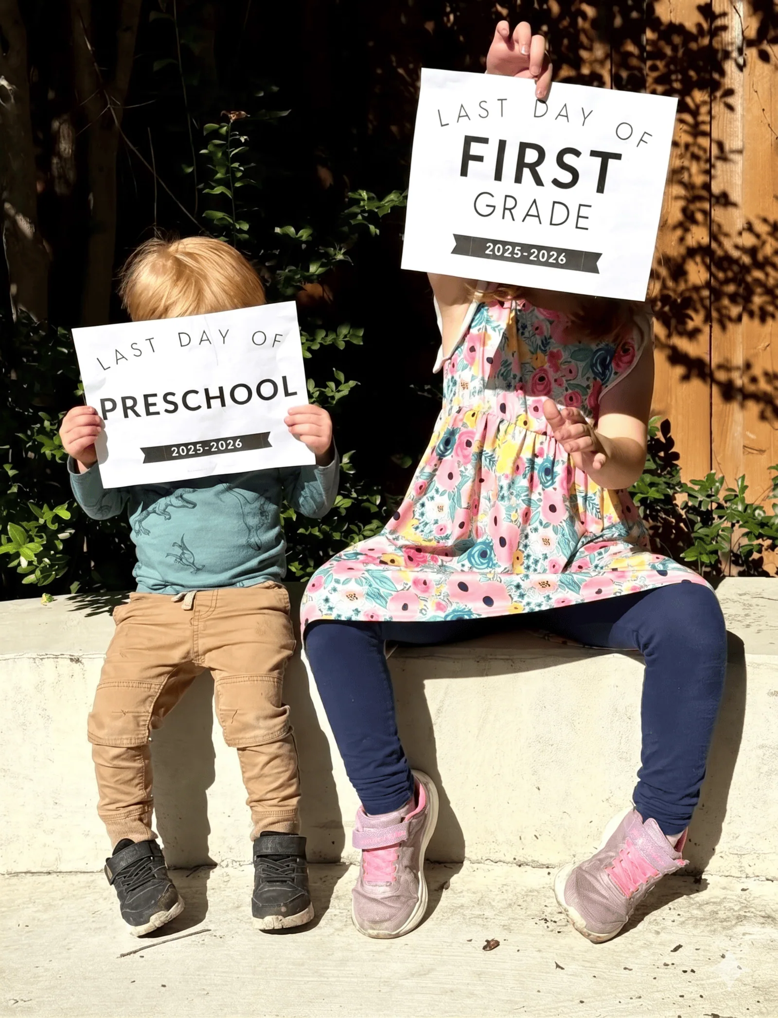 2 children holding last day of school signs for 2026