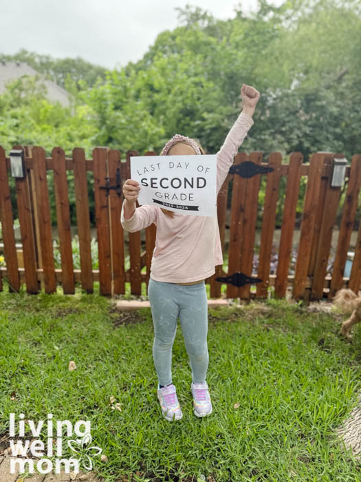 Girl holding a free printable last day of school sign