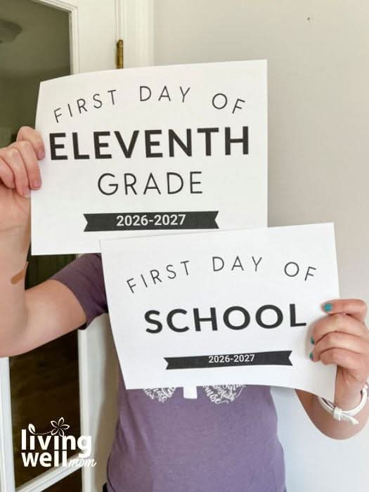 Girl holding 2 first day of school signs