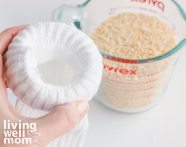 Woman filling a sock with dry rice to create a diy heating pad