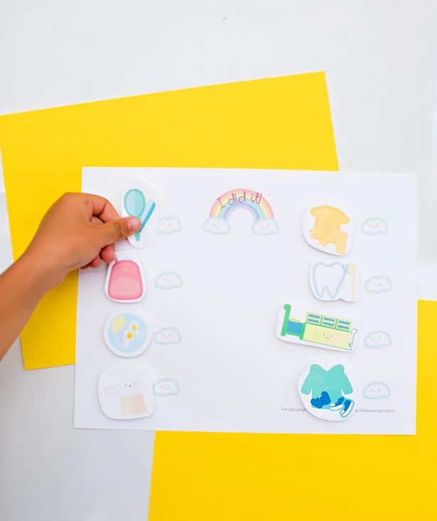 adding stickers to colorful yellow chore chart for kids