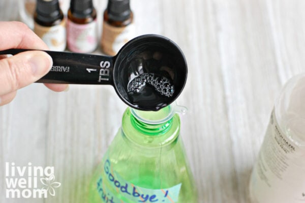 Mixing together essential oils in a spray bottle to help get rid of fruit flies