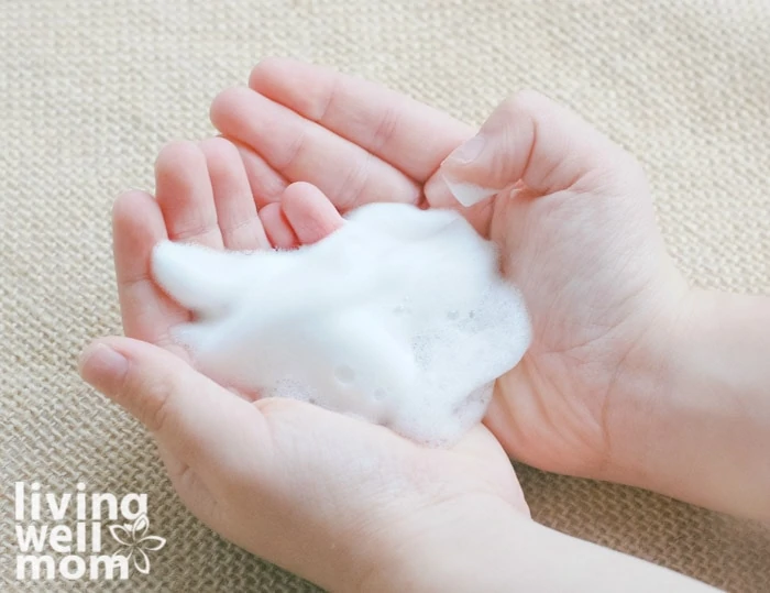 child with foaming hand soap in hands