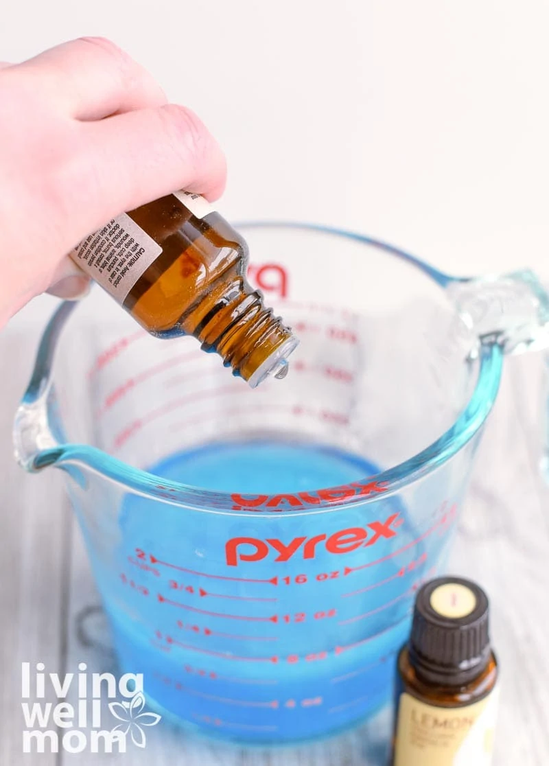 adding tea tree essential oil to glass measuring cup