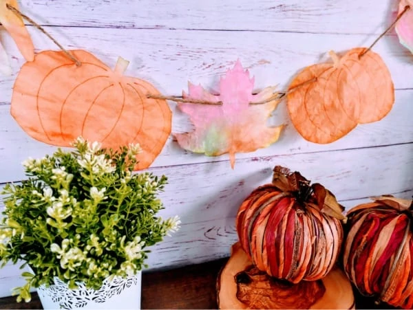 garland with painted pumpkins and leaves made from coffee filters