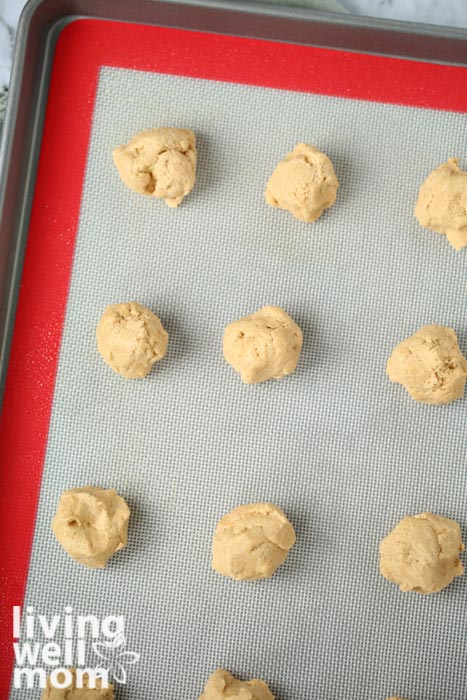 Peanut butter cookie rounds on a baking sheet