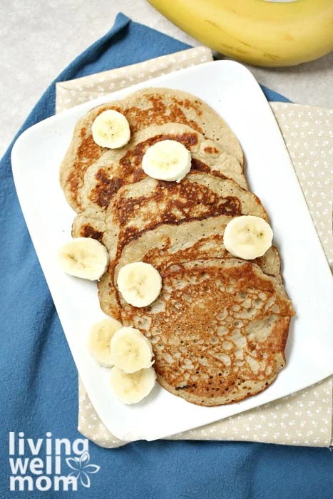 Banana egg pancakes cooked and topped with sliced bananas.