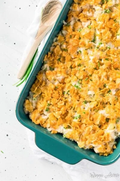 chicken and rice casserole in a dish on a table with a wooden spoon next to it