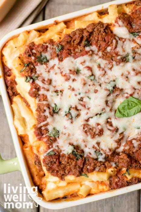 baking dish with baked ziti with ricotta and a basil leaf on top
