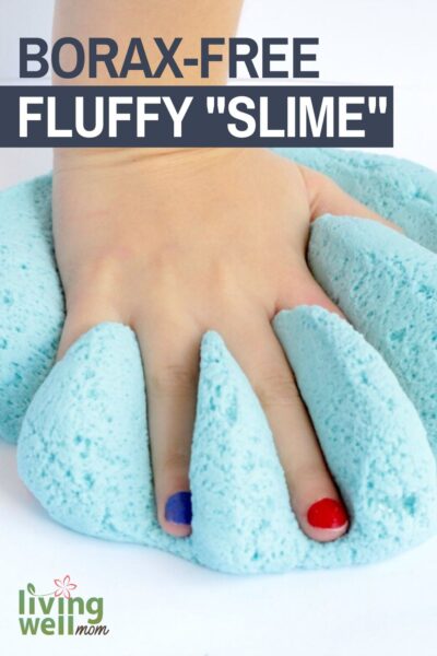 Child's hand pushing blue fluffy slime