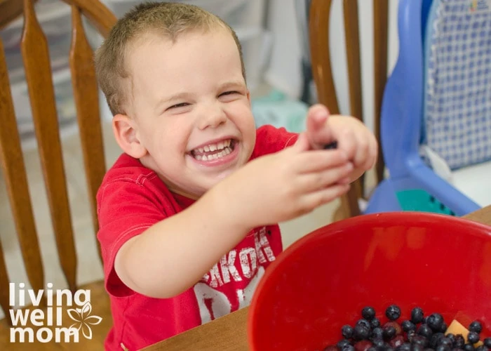 baby picking stems off of blueberries