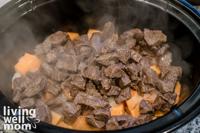 Chunks of beef on top of cubed sweet potatoes